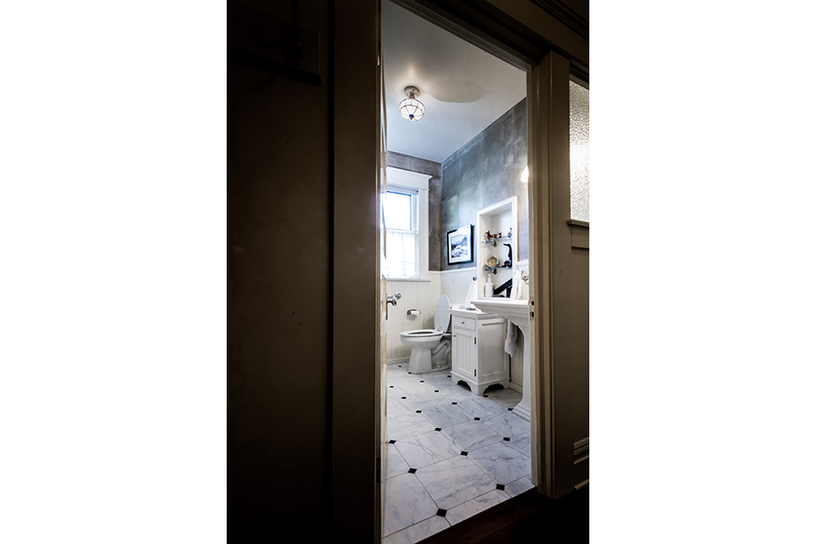 A first-floor bathroom with white decor and no threshold allows visitors easy access to the facilities.